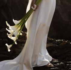 a woman in a wedding dress holding flowers