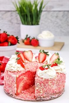 a cake with strawberries and whipped cream is on a plate next to some flowers