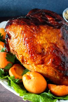 a roasted chicken on a platter with carrots and other vegetables next to it