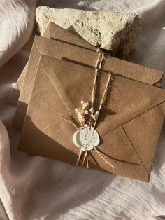 an envelope with a waxed seal on it and some dried flowers tied to it