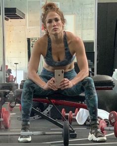 a woman sitting on top of a bench in a gym