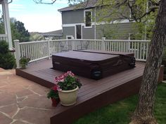 a brown suitcase sitting on top of a wooden deck next to a potted plant