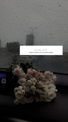 flowers sitting on the dashboard of a car in front of a rain soaked window with text overlay