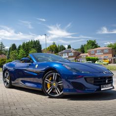 a blue sports car is parked on the street