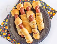 hot dogs wrapped in bread on a plate