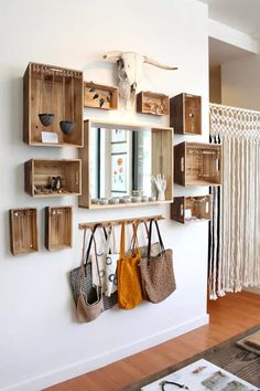 the wall is filled with wooden boxes and purses hanging on it's sides