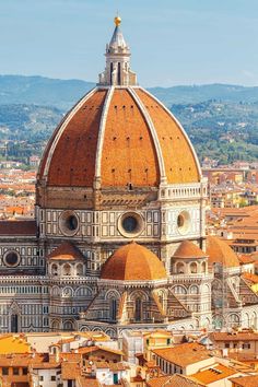 an aerial view of the dome of a church in italy, with rooftops and buildings surrounding it