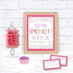 a pink cupcake and some candy on a table with a sign that says, how many sprinkles are in the jar?