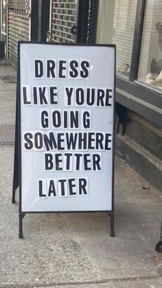 a sign on the sidewalk that says dress like you're going somewhere better later