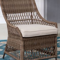 a wicker chair sitting on top of a blue rug