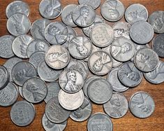 a pile of silver coins sitting on top of a wooden table