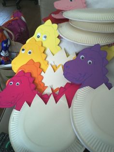 paper plates with cutouts of different colored animals on them, sitting next to each other