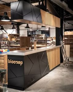 the interior of a restaurant with wood and metal accents on the walls, along with black lighting fixtures