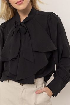 Get ready to add some playful flair to your wardrobe with our Ruffles Blouse! Featuring long balloon sleeves with buttoned cuffs, a pretty tie-neck, and gentle ruffles at the front, this blouse brings fluttery movement to any outfit. The button-down bodice offers a classic fit and ends with a rounded hem for a stylish touch. 100% Polyester Chic Formal Blouse With Ruffle Sleeves, Elegant Puff Sleeve Top With Tie Sleeves, Fall Puff Sleeve Top With Bow, Chic Ruffled Office Blouse, Fall Workwear Blouse With Ruffle Hem, Workwear Puff Sleeve Blouse With Bow, Chic Office Blouse With Ruffles, Workwear Puff Sleeve Blouse With Tie Sleeves, Office Blouse With Ruffled Collar And Ruffles