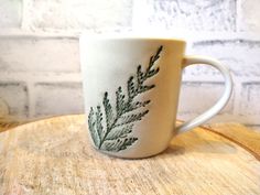 a white coffee cup sitting on top of a wooden table