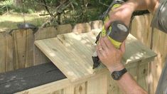 a man using a power tool on a wooden fence