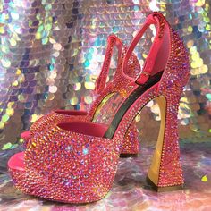 The breathtaking sparkle of these pink platform cone heels will satisfy your nostalgic Y2K costume fantasies. Custom embellished with thousands of hand placed iridescent pink/orange glass rhinestones they are truly dazzling in any light. The pink base color of the shoe is blacklight reactive giving these gals a unique flavor of sparkle. The color shifts based on the lighting. Photos and video really can't capture just how incredibly gorgeous these are in person. The heel height it 5.25 inches. T Pink Platform Heels For Prom, Glamorous Pink Heels For Party, Pink Sequined Round Toe Heels, Evening Pink Bling Heels, Pink Rhinestone Heels With Round Toe, Pink Rhinestone Round Toe Heels, Wedding Pink Sparkling Heels, Pink Sparkling Heels For Evening, Glamorous Pink Heels With Sequins