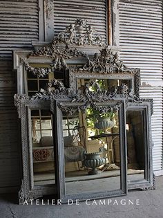 an ornately decorated mirror is shown in front of a wall with shuttered doors