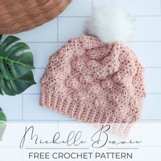 a crocheted beanie with a white pom - pom on top