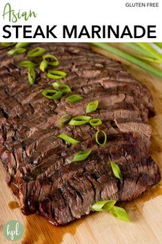 a piece of steak on a cutting board with green onions