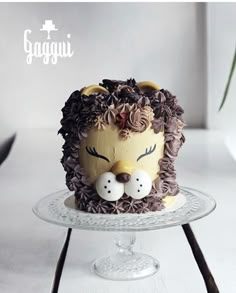 a cake decorated to look like a lion with two birds on its head and the words goggi written above it