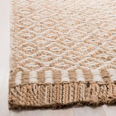 a close up of a rug on the floor with white and brown stripes in it