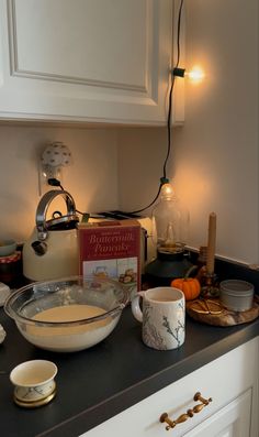 the kitchen counter is cluttered with dishes and candles