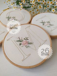 three embroidery hoops with flowers on them and the words df pattern written in cursive letters