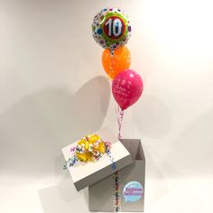 a birthday cake and balloons in a box