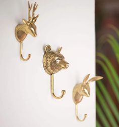 three brass deer hooks hang on the wall