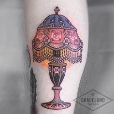 a woman's leg with a lamp tattoo on it