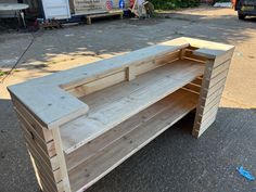 a wooden bench sitting on the side of a road