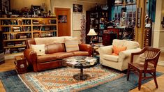 a living room with couches, chairs and bookshelves on the shelves in front of them