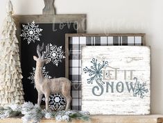 a christmas mantel with a deer, snowflakes and a sign that says let it snow