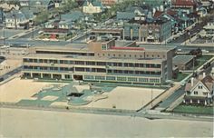 an aerial view of a large building with lots of windows and buildings in the background