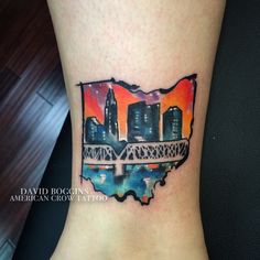 a watercolor tattoo with the shape of a city on it's side ankle