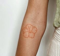 a woman's arm with a flower tattoo on the left side of her arm