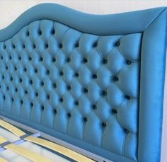 an upholstered blue headboard on a bed