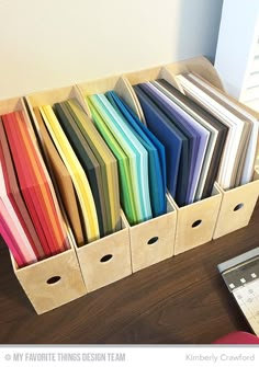 a wooden box filled with lots of different colored papers