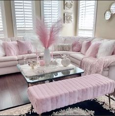 a living room filled with pink furniture and decor