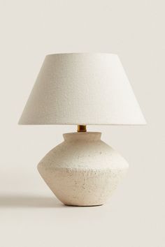 a white table lamp with a beige shade on it