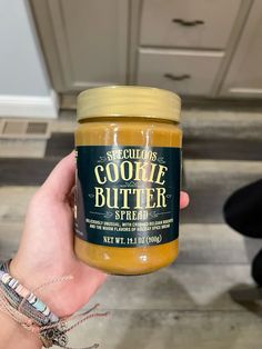 someone holding up a jar of cookie butter