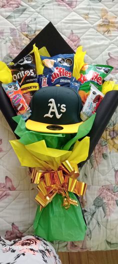 a baseball hat and candy bouquet on a bed