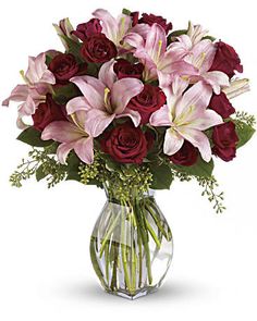 a vase filled with lots of pink and red flowers