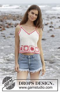 a beautiful young woman standing on top of a beach next to the ocean with her hands in her pockets