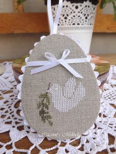 an embroidered ornament on a doily next to a potted plant