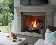 a living room with a fire place in the center and a television on top of it