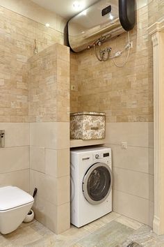 a washer and dryer in a bathroom with beige tiles on the wall behind it