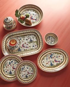 an assortment of decorative dishes on a red table