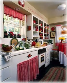 a kitchen with red and white decor on the counters, cabinets, and stove top oven